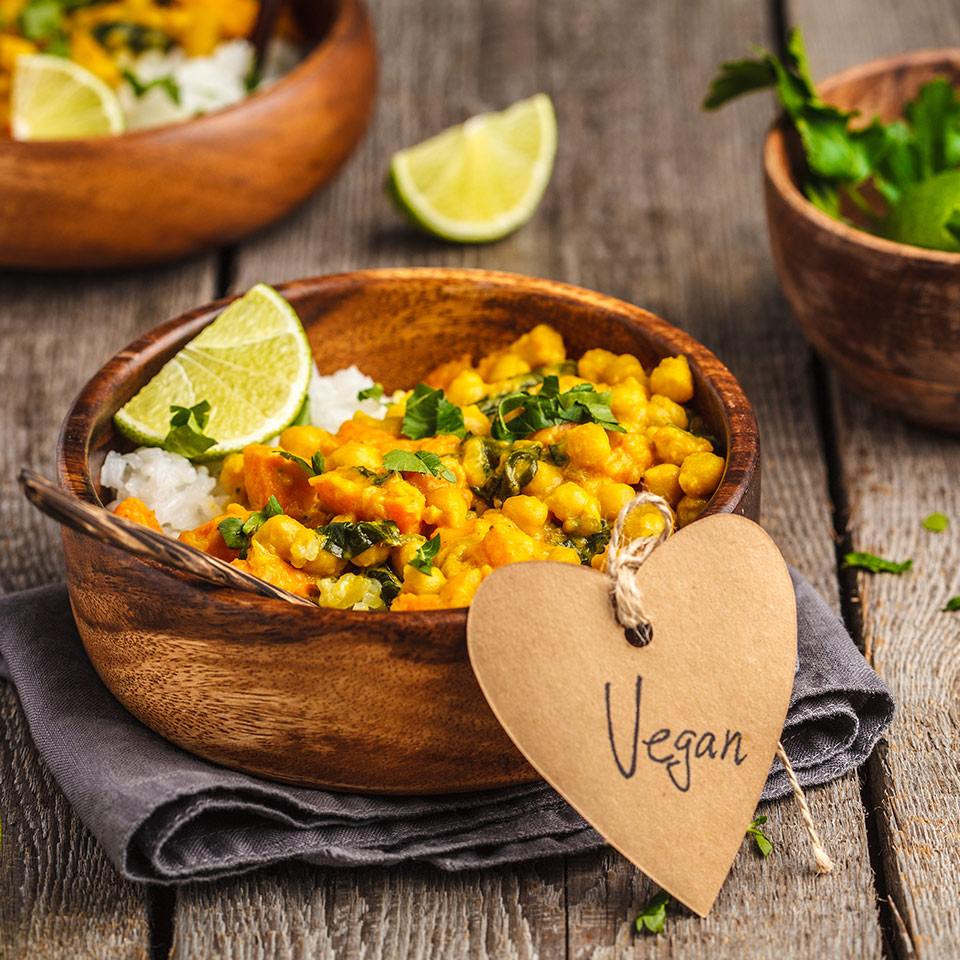 Vegan curry in wooden bowl on a wooden background